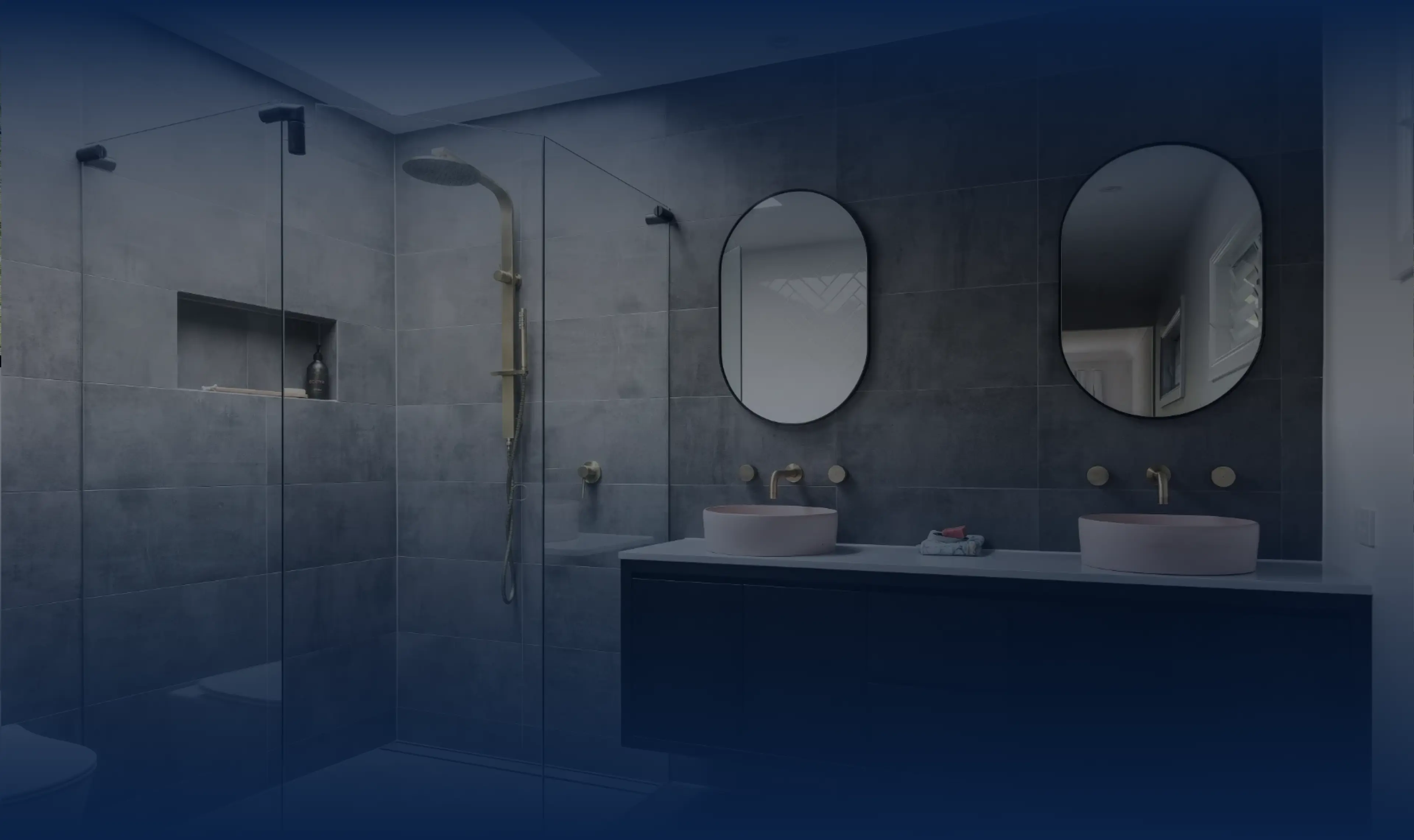 Contemporary grey tiled bathroom with gold fittings, showcasing refined craftsmanship and minimalist precision.
